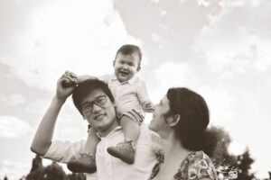 bébé rigole sur les épaules de papa
