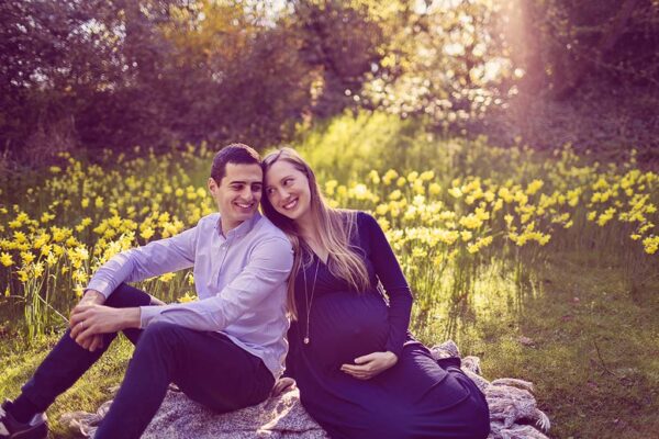 future maman en robe fluide dans un parc en fleurs