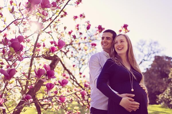 couple attendant un bebe sous les arbres en fleurs