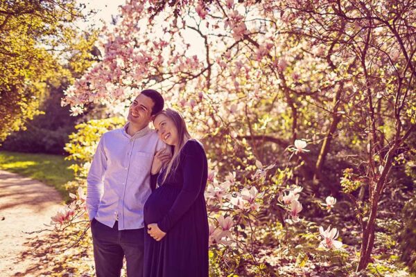 shooting grossesse printemps en couple dans un parc en fleurs